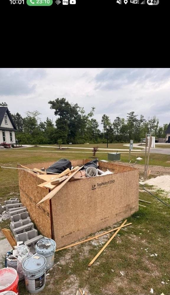 Construction offcuts, sheeting and buckets stacked in a plywood bin on a new-build lot